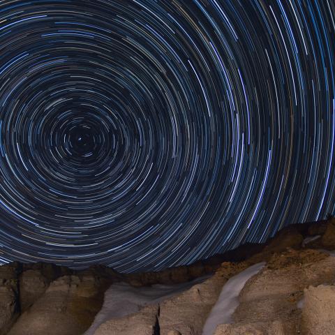 photo of star trails above rocky horizon
