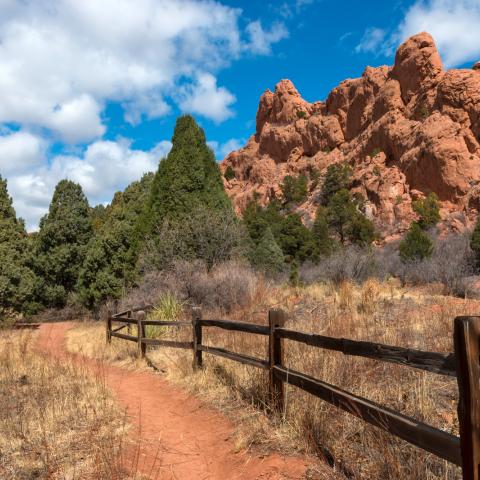 photo of reddish rock formations and wooden fence