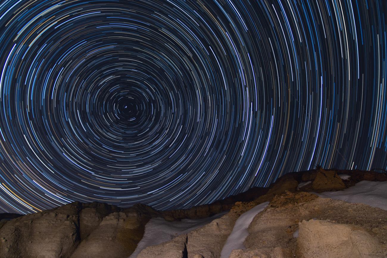 photo of star trails above rocky horizon