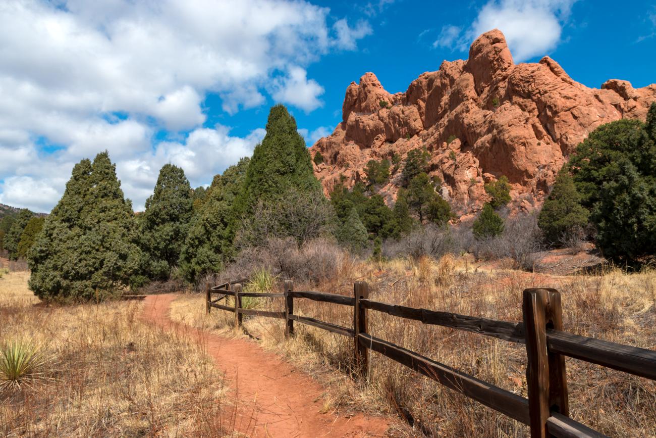 photo of reddish rock formations and wooden fence