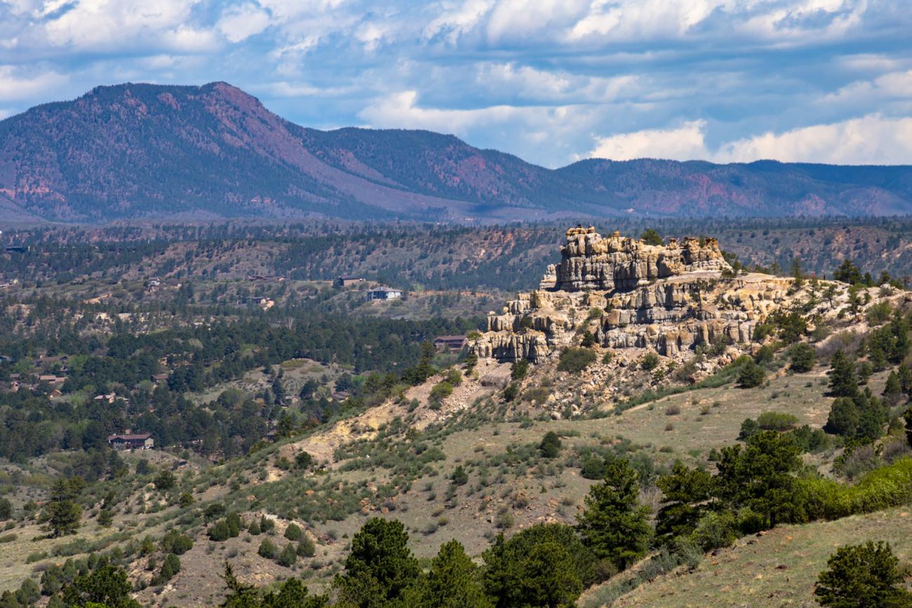 photo of a rock formation in front of a mountain range